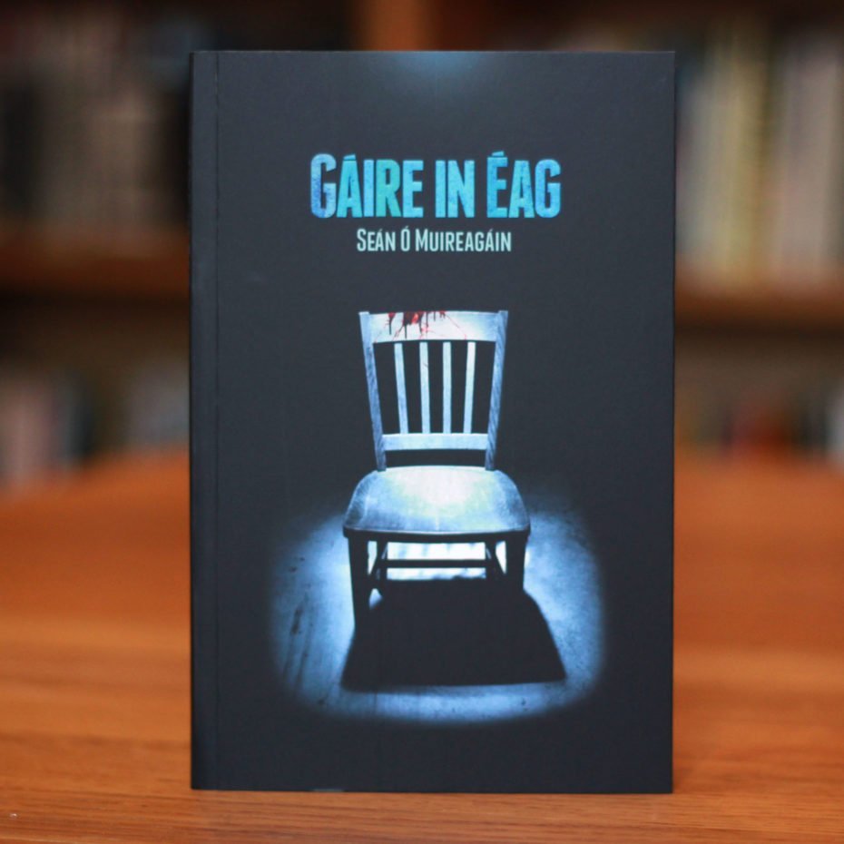 Cover of book Gáire in Éag depicting a bloodied chair under a harsh spotlight.
